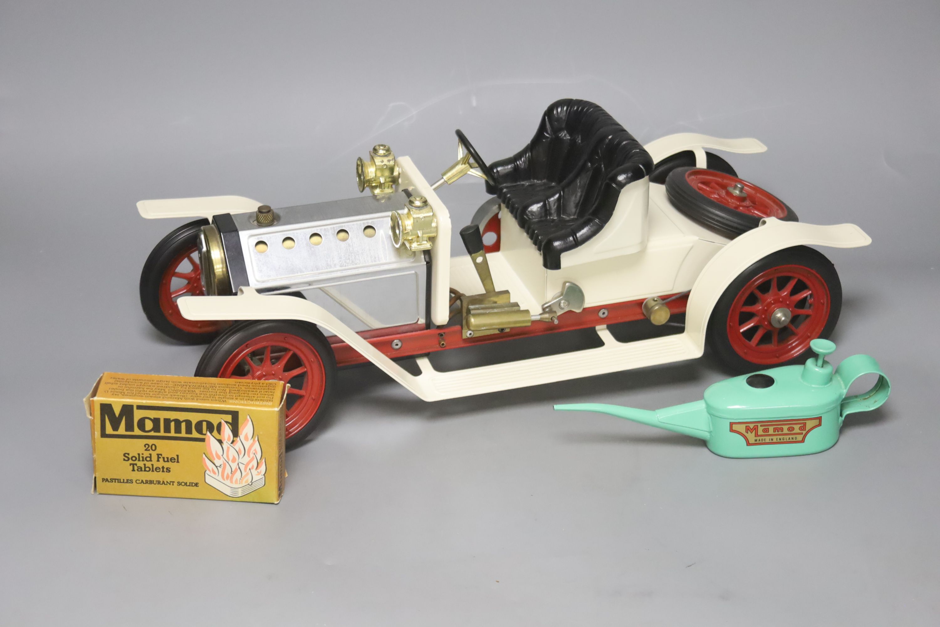 A Mamod live steam vintage two-seater roadster, with silver and cream paintwork and red wheels, oil can